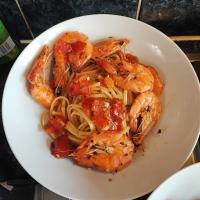 Shrimps with tomatoes and parsley on the pan