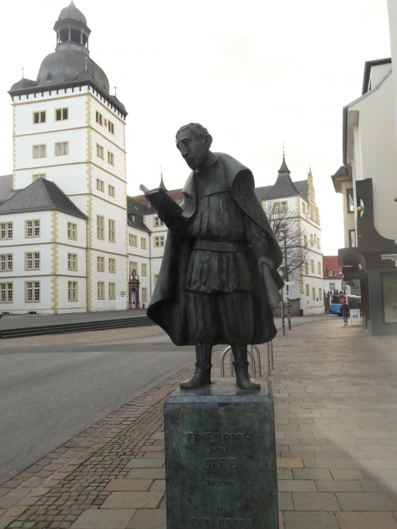 Bronze statue of Friedrich von Spee reading a book